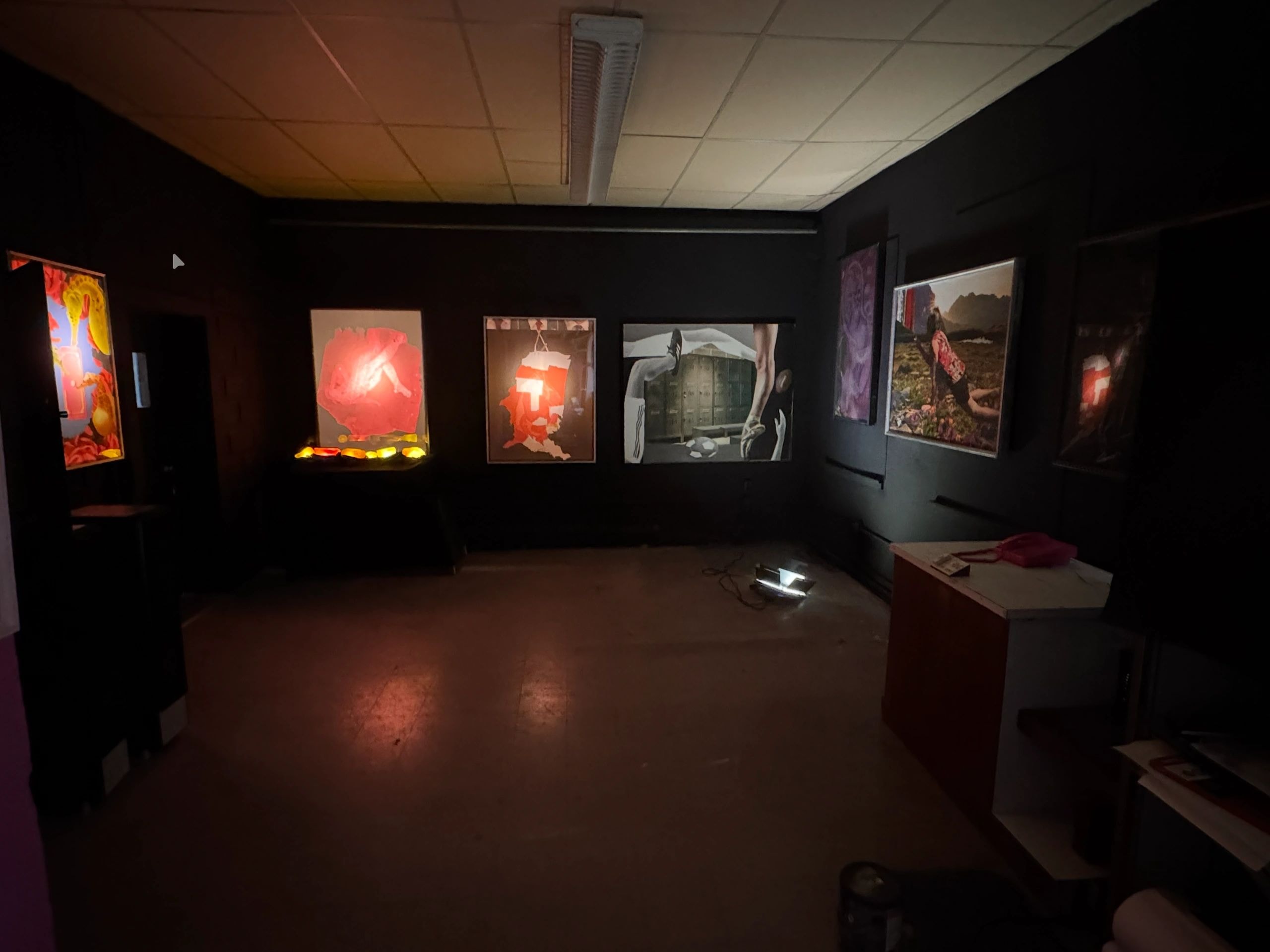 Dark gallery interior with vibrant artworks